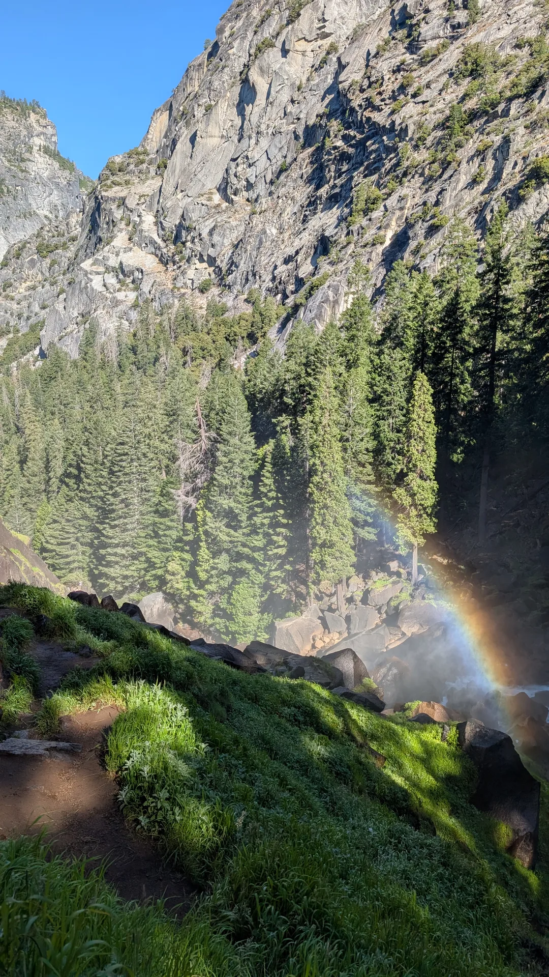 vernal fall in a wall of mist, a rainbow curving through its base