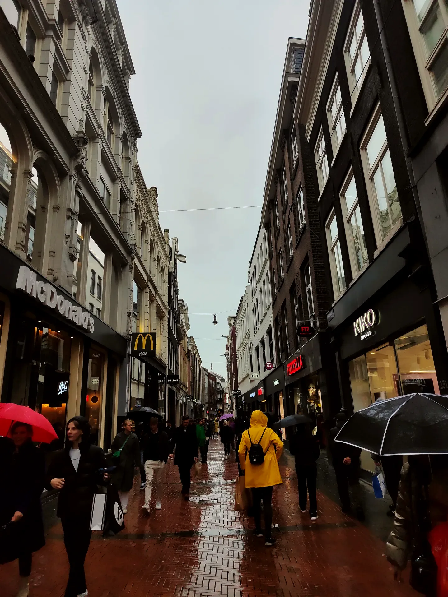 one yellow raincoat on wet kalverstraat