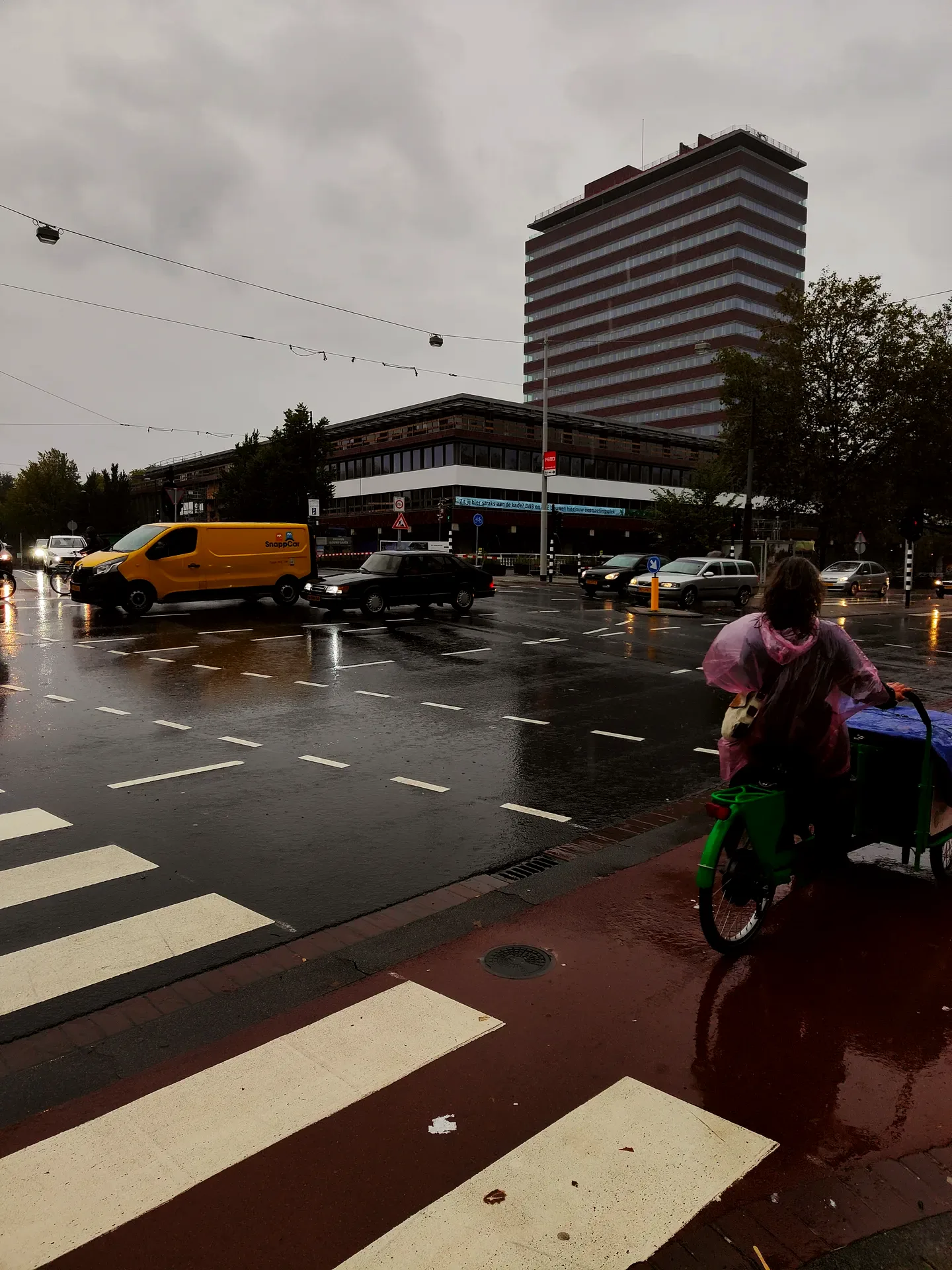 a pink poncho in the de pijp rain