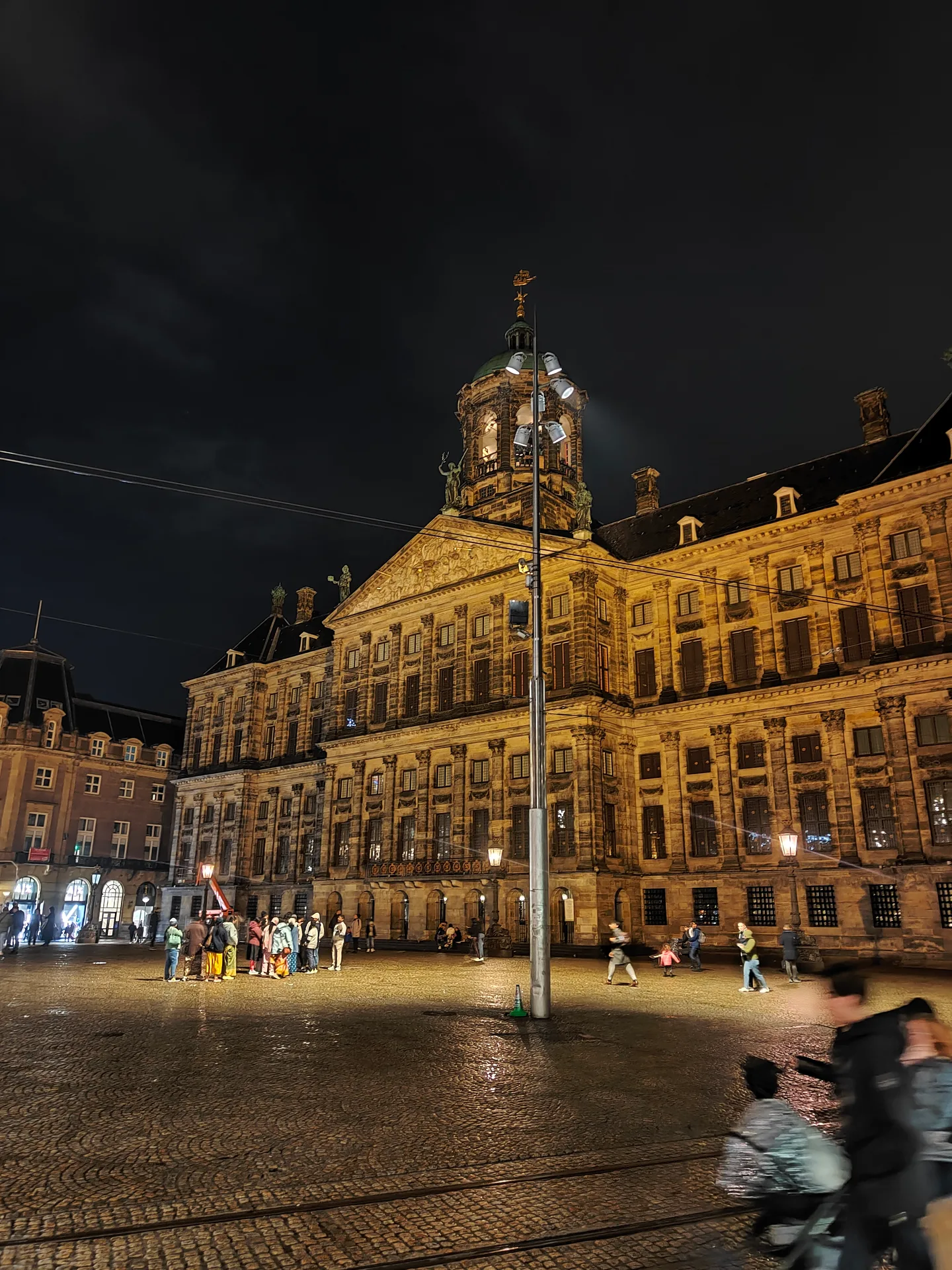 the royal palace gone gold over a dark dam square